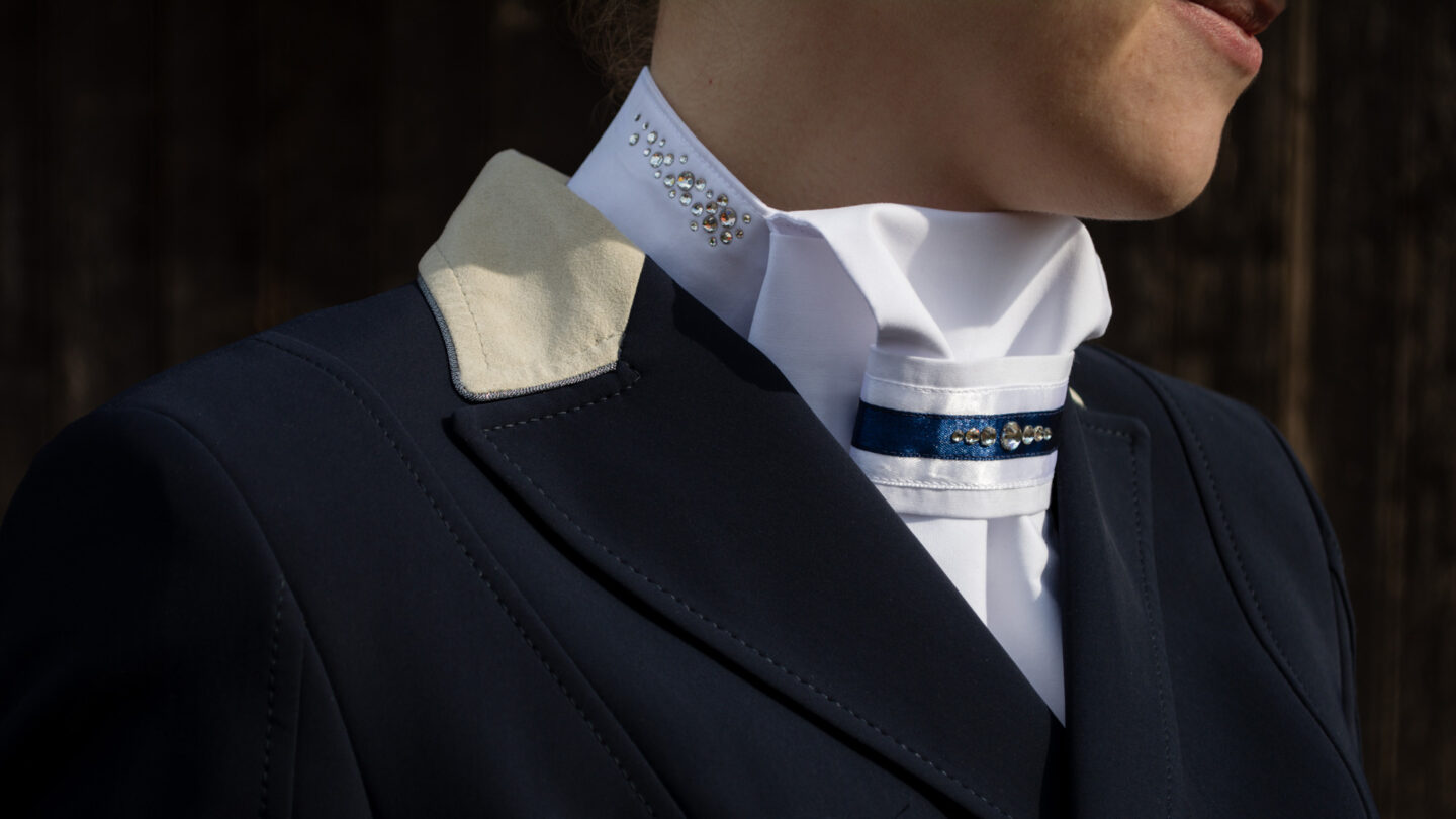 Reiterin mit Schiller Manufaktur-Plastron und Classic-Riegel Navy im Turnierjackett